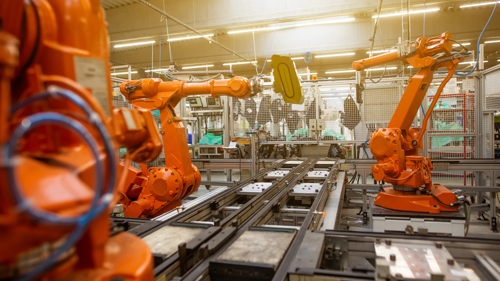 Orange industrial robots on an automated production line